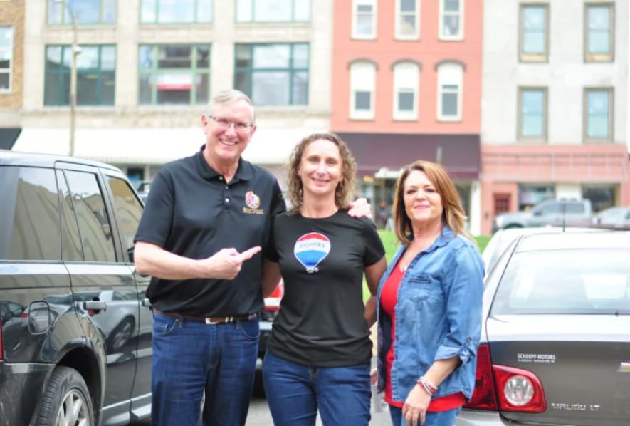 A couple with a real estate agent in the middle